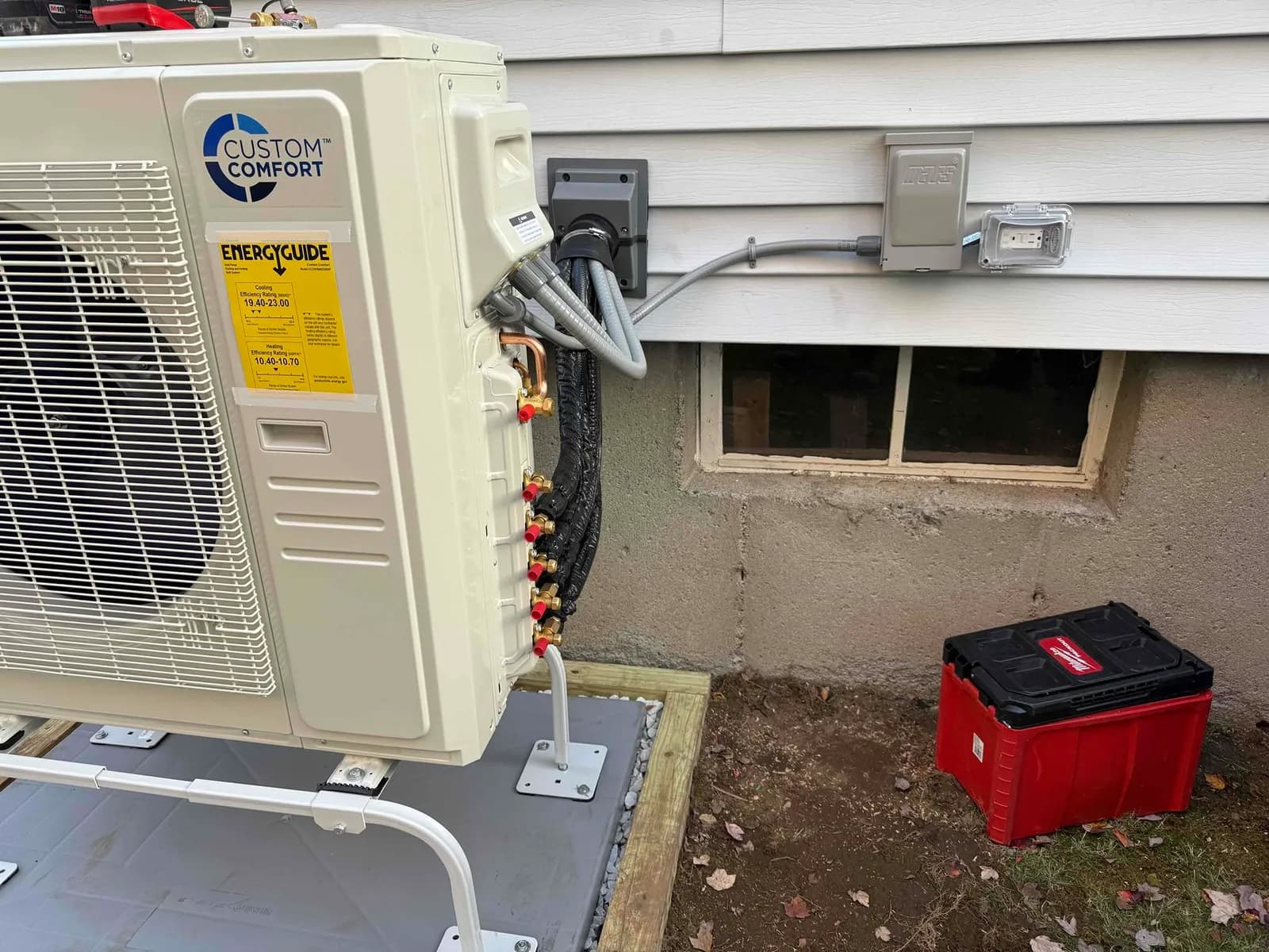 Outdoor heat-pump condenser with a new disconnect and weather-resistant outlet on the house siding