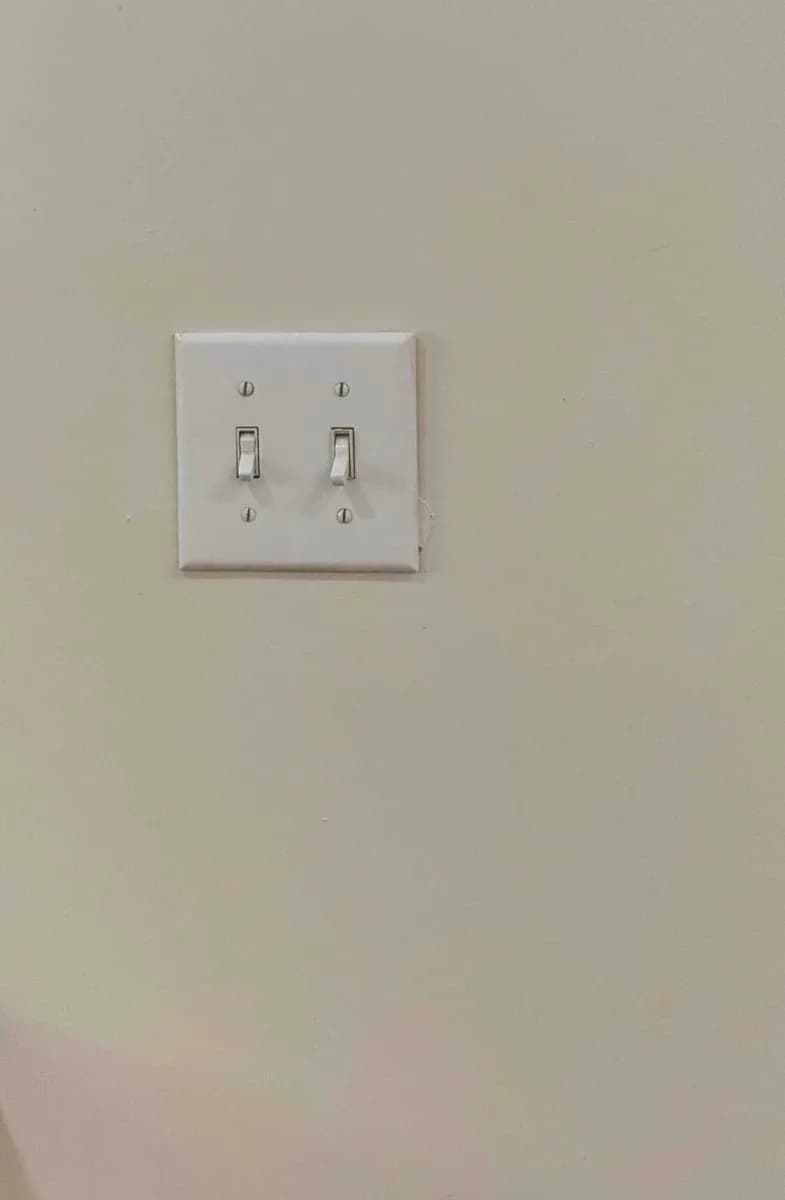 Two new toggle light switches installed with a clean wall plate